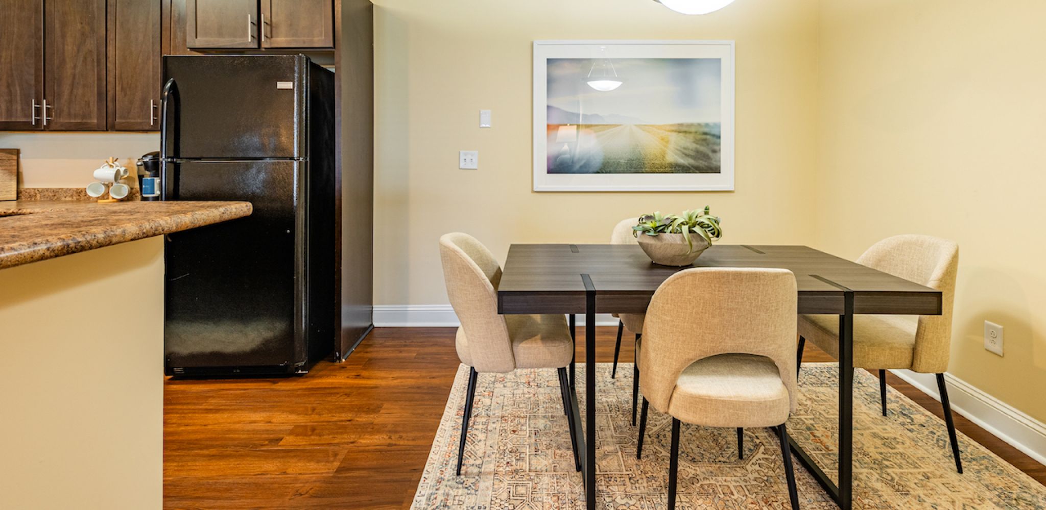 Hawthorne Crestview apartment dining area with table, rug, and chairs next to kitchen